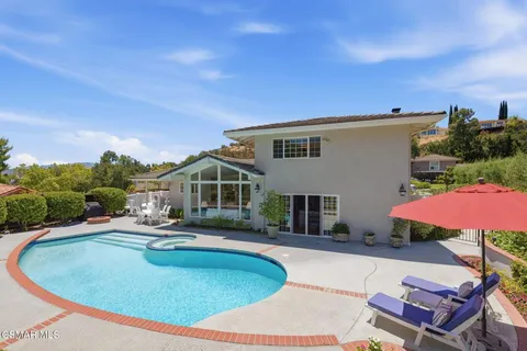 a view of a house with pool and chairs