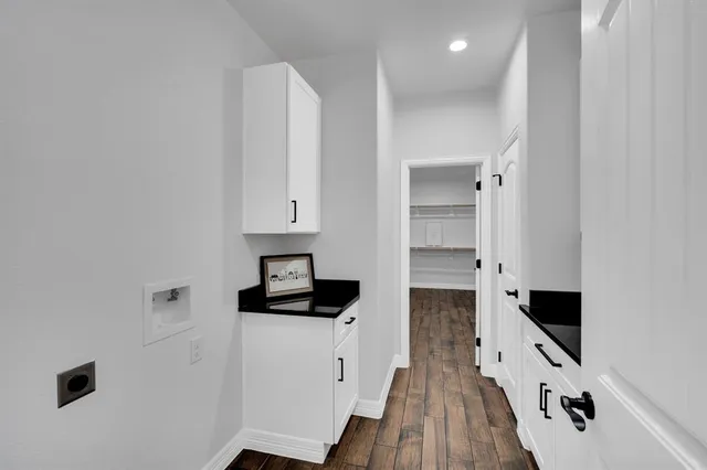 a kitchen with a refrigerator and white cabinets