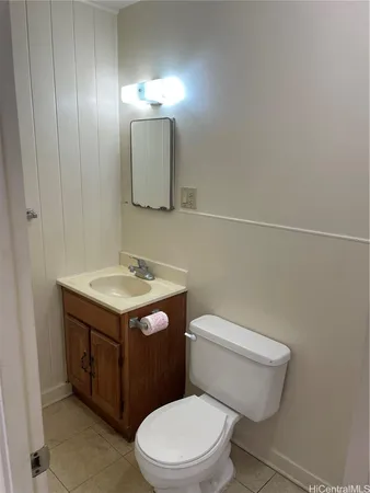 a bathroom with a toilet sink vanity and mirror