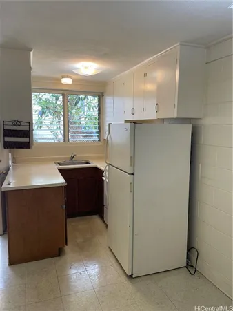 a kitchen with stainless steel appliances a refrigerator a sink a stove and white cabinets