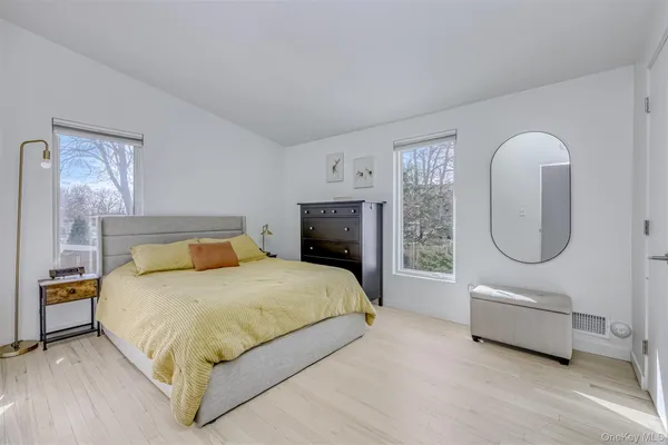a bedroom with a bed a table and potted plant