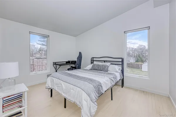 a bedroom with bed a lamp and a window