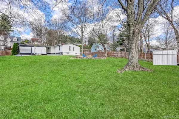 a white house with a big yard and large trees