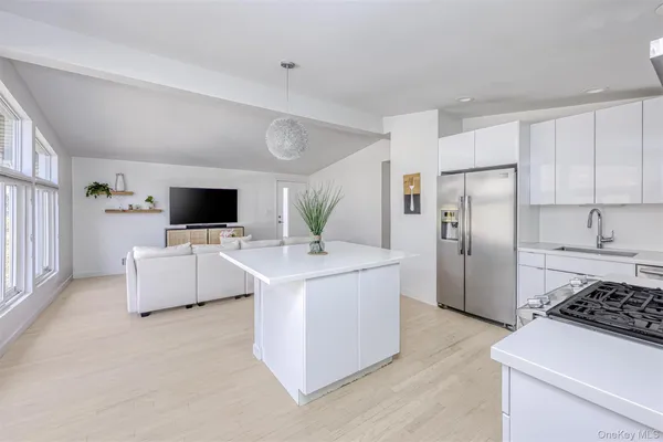 a kitchen with stainless steel appliances a white stove top oven a sink and a refrigerator