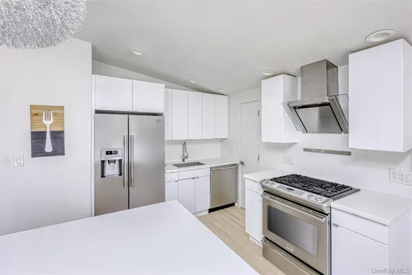 a kitchen with stainless steel appliances a refrigerator stove and sink