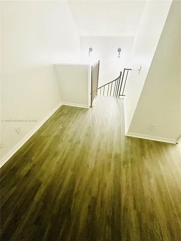 a view of a room with wooden floor