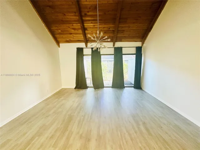 a view of a room with wooden floor and windows
