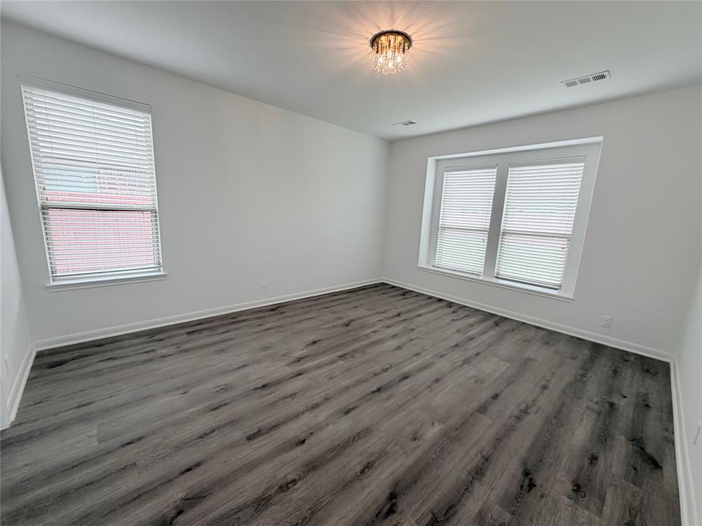 3310 Tanseyleaf Drive Forney, TX 75126 - Photo 23 of 33 an empty room with wooden floor and windows