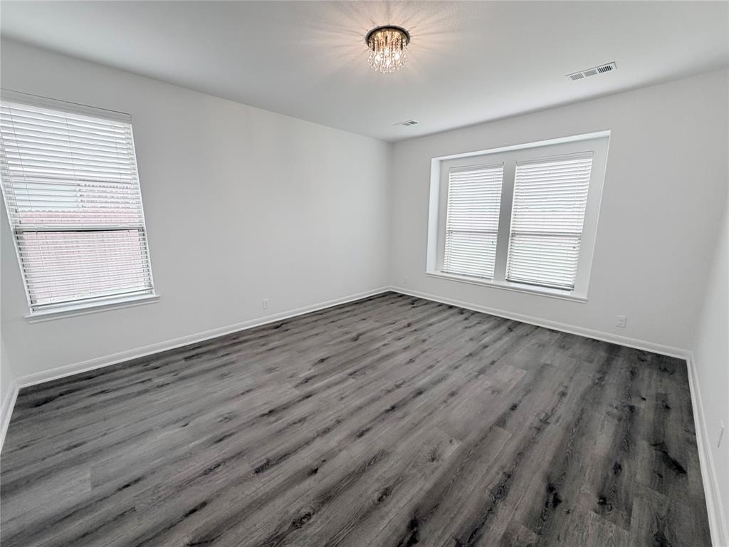 3310 Tanseyleaf Drive Forney, TX 75126 - Photo 24 of 33 an empty room with wooden floor and windows