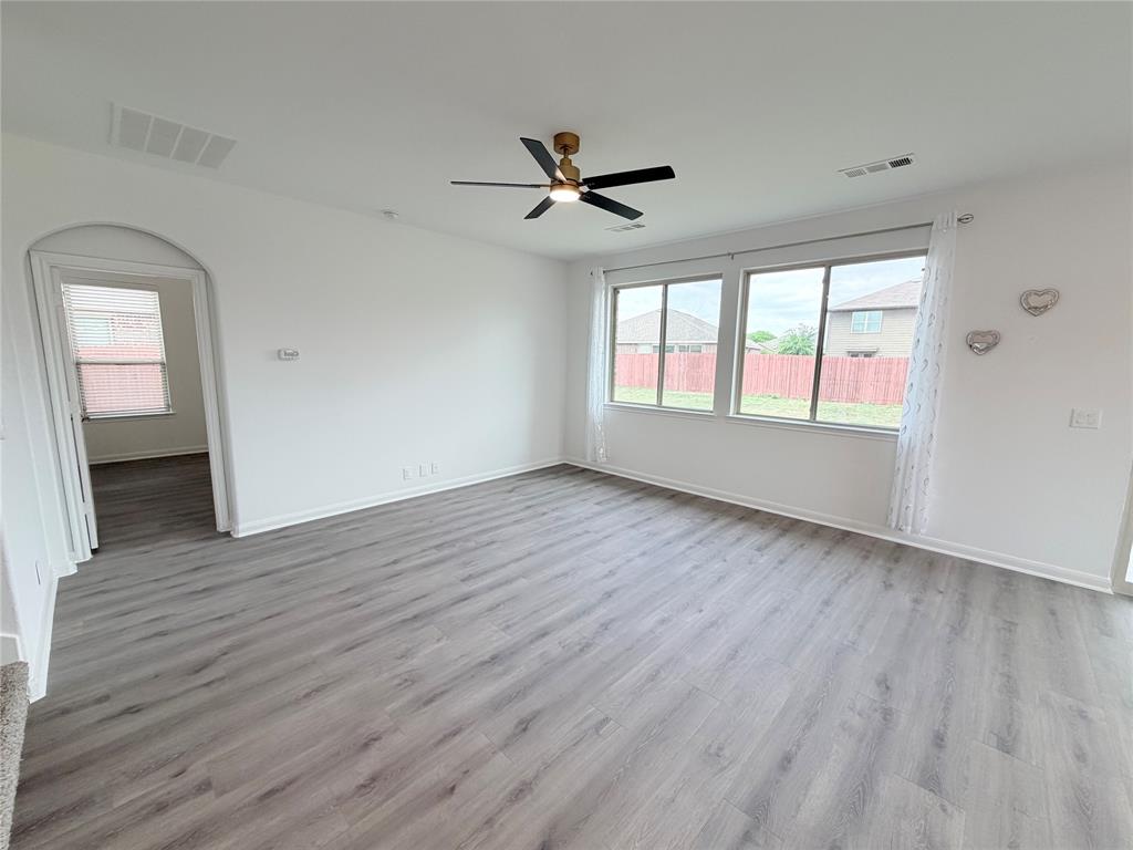 3310 Tanseyleaf Drive Forney, TX 75126 - Photo 25 of 33 an empty room with wooden floor chandelier fan and windows