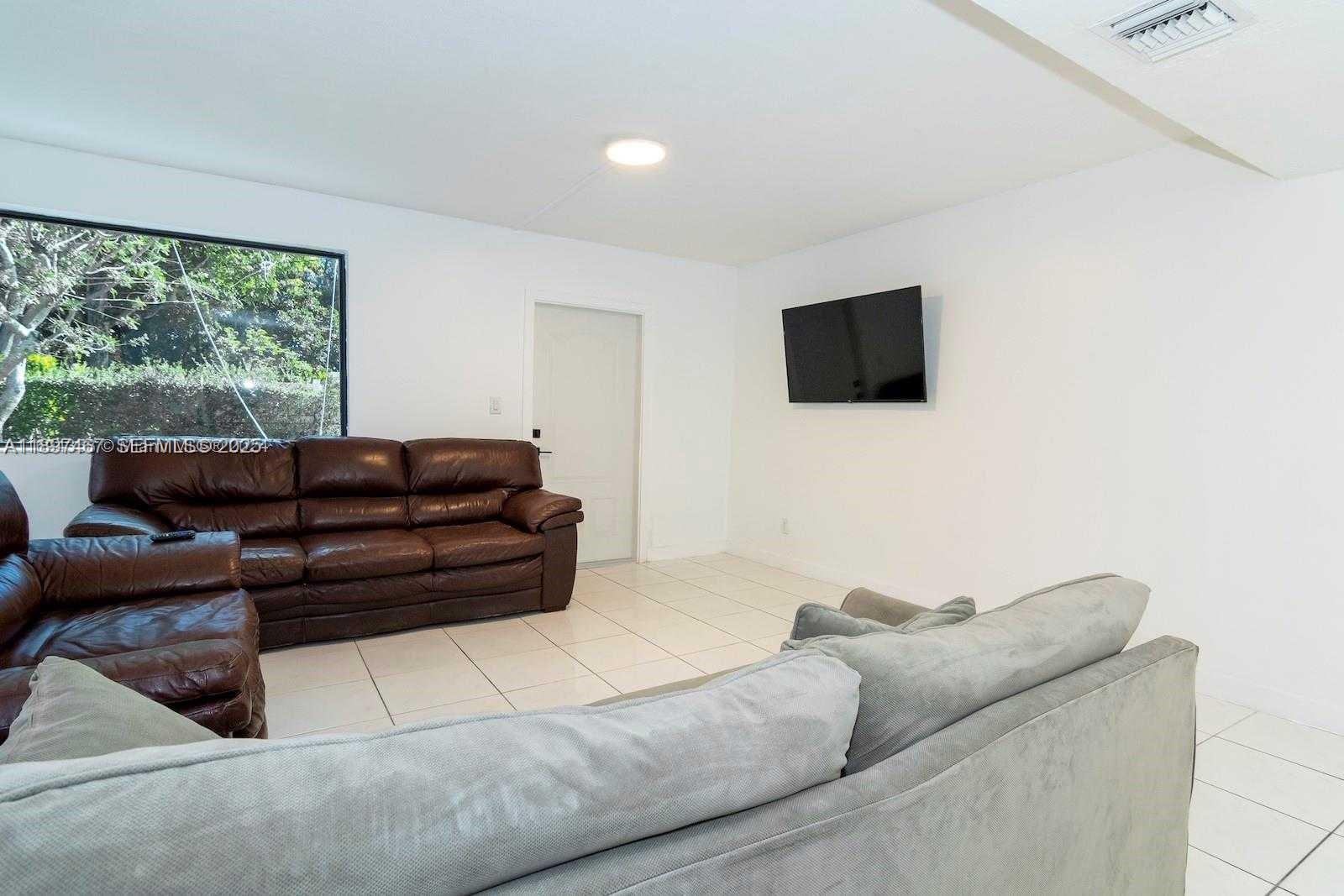 2729 Southwest 67th Avenue Miami, FL 33155 - Photo 14 of 39 a living room with furniture and a flat screen tv