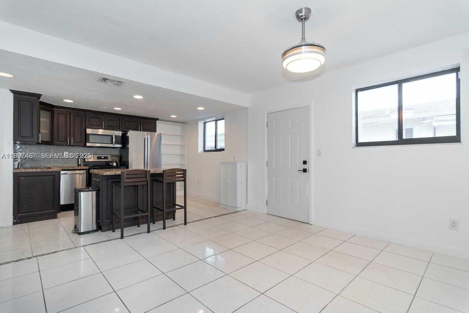 2729 Southwest 67th Avenue Miami, FL 33155 - Photo 15 of 39 a kitchen with stainless steel appliances granite countertop a stove top oven a sink a counter space and cabinets