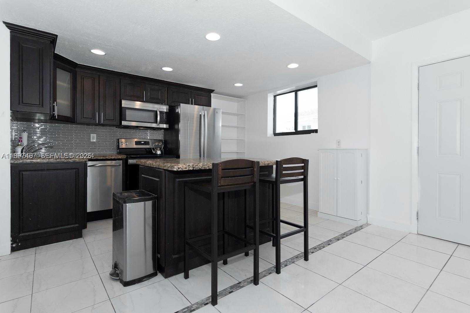 2729 Southwest 67th Avenue Miami, FL 33155 - Photo 17 of 39 a kitchen with stainless steel appliances granite countertop a sink counter space and cabinets