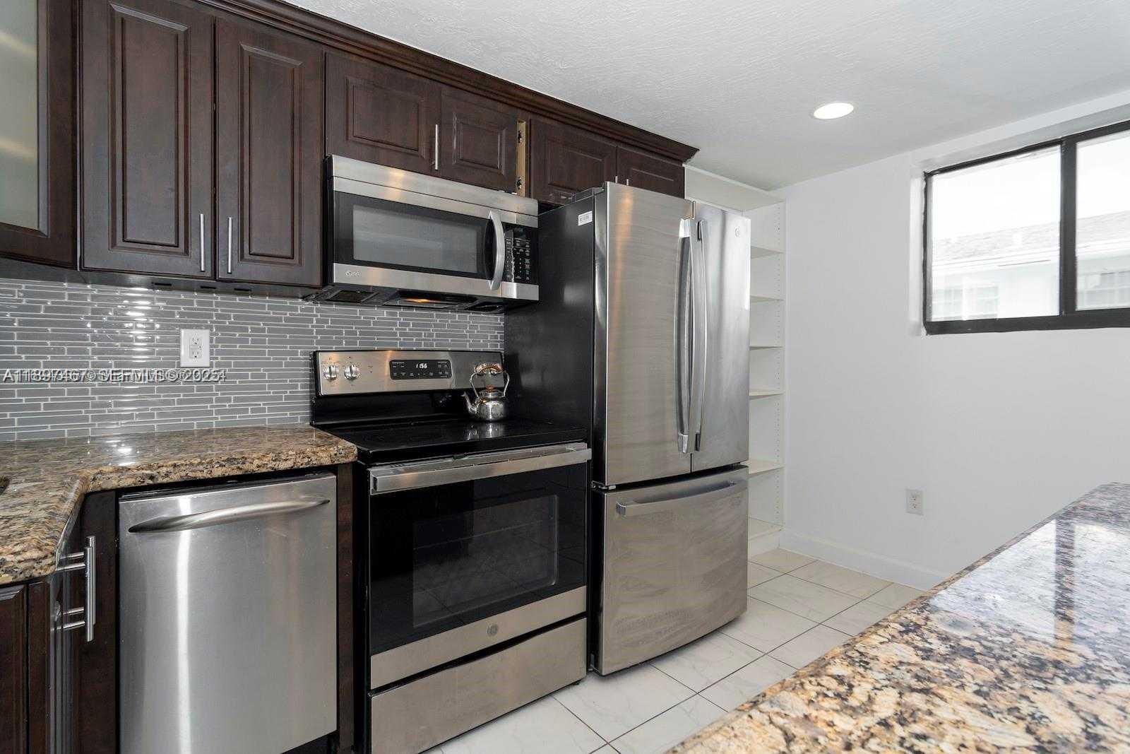 2729 Southwest 67th Avenue Miami, FL 33155 - Photo 18 of 39 a kitchen with stainless steel appliances granite countertop a refrigerator microwave and sink