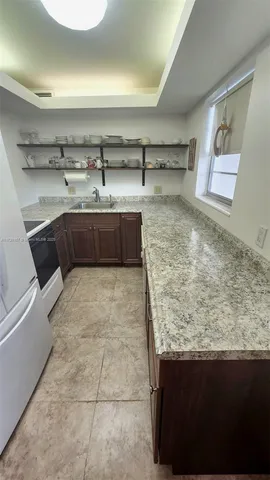 a kitchen with stainless steel appliances granite countertop a sink a stove and a microwave