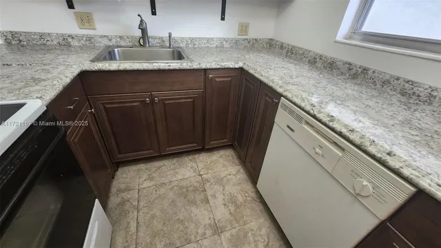 a kitchen with granite countertop a sink and a stove