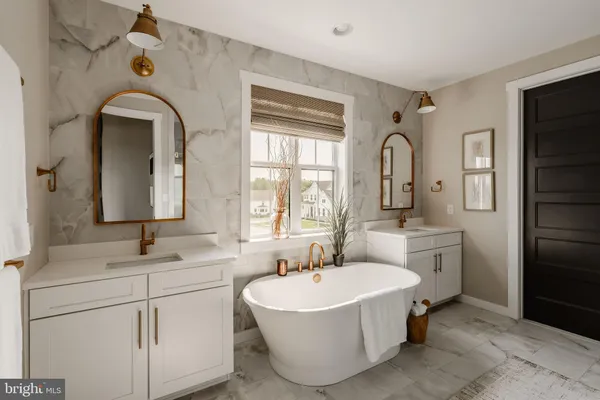 a bathroom with a double vanity sink a mirror and a bathtub