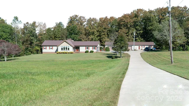 a view of an house with backyard and trees