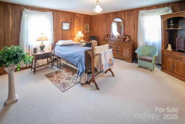 a bed room with furniture a window and a flat screen tv