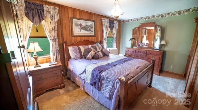 a bedroom with a bed next to a window