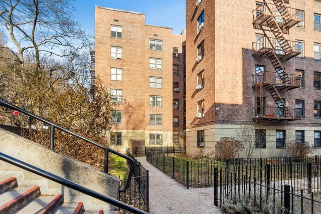 a view of a brick house with wooden fence