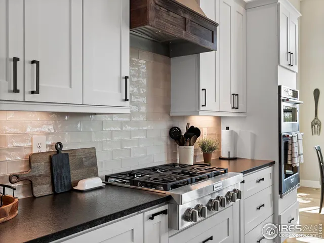 a kitchen with granite countertop a sink stainless steel appliances and cabinets