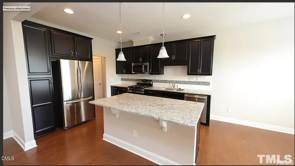 a kitchen with kitchen island a counter top space stainless steel appliances and cabinets