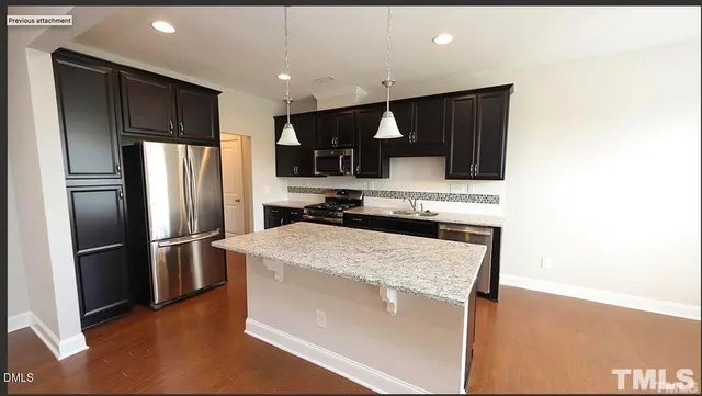 a kitchen with kitchen island a counter top space stainless steel appliances and cabinets