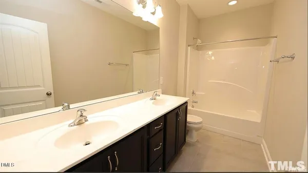 a bathroom with a double vanity sink toilet and shower