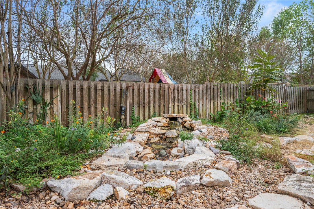 713 Willow Loop College Station, TX 77845 - Photo 35 of 39 a view of a backyard with a small cabin and a chair