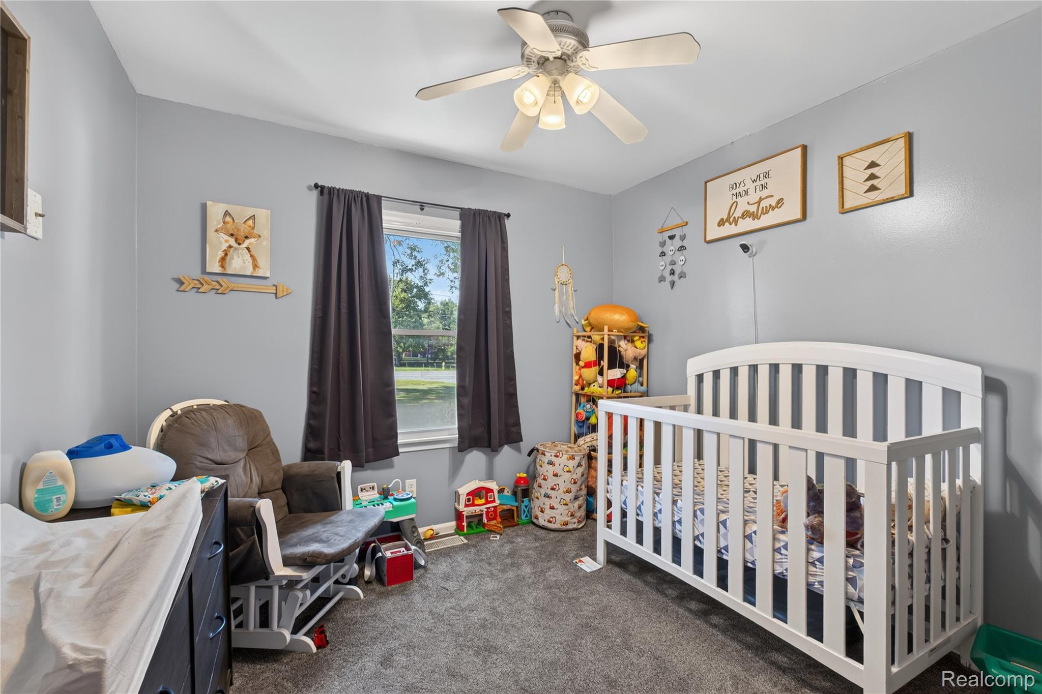5282 West Mount Morris Road Mount Morris, MI 48458 - Photo 12 of 23 Bright secondary bedroom featuring soft blue walls, ceiling fan with integrated lighting, and a white vertical-slat crib