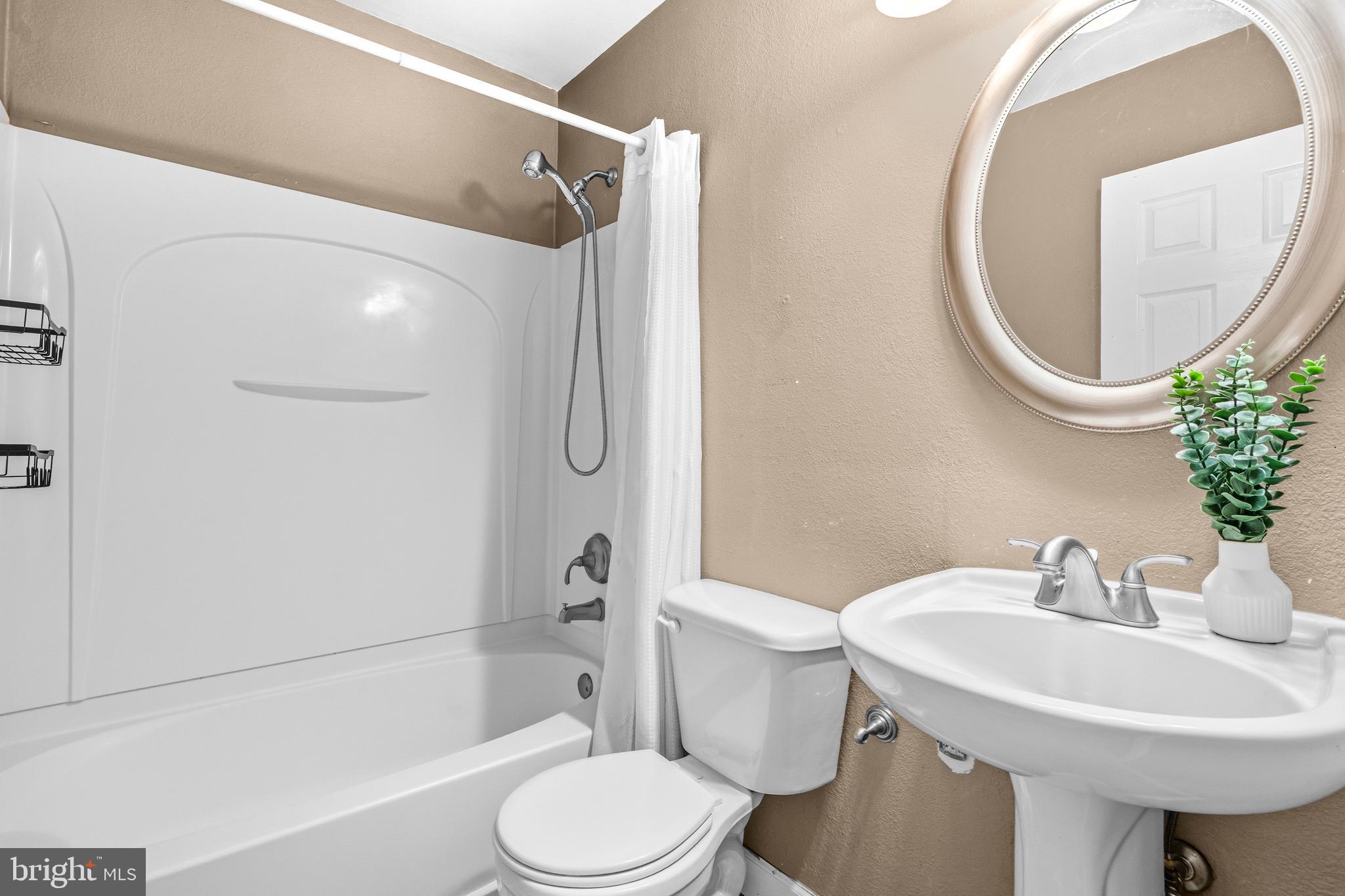 236 Inlet Drive Pasadena, MD 21122 - Photo 15 of 33 a bathroom with a sink a toilet and a mirror