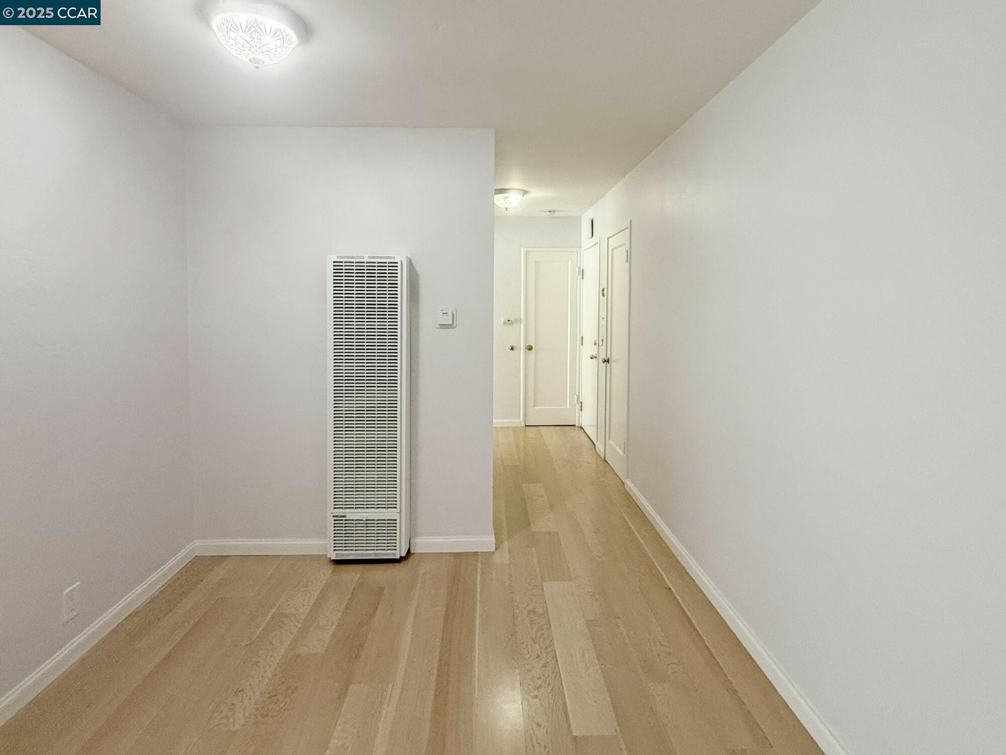 1919 Curtis Street Berkeley, CA 94702 - Photo 11 of 54 a view of room with wooden floor and white walls