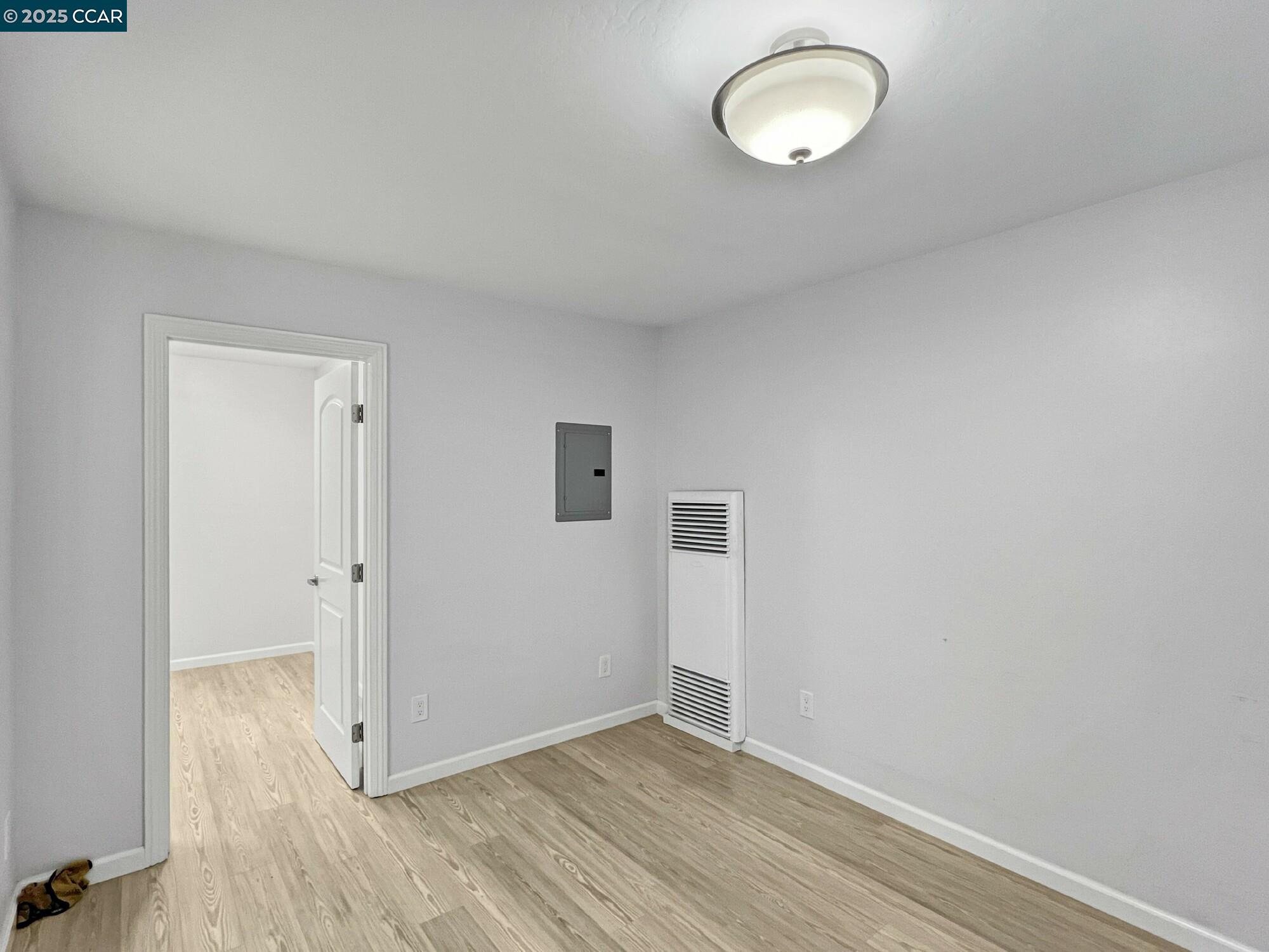 1919 Curtis Street Berkeley, CA 94702 - Photo 13 of 54 an empty room with wooden floor and windows