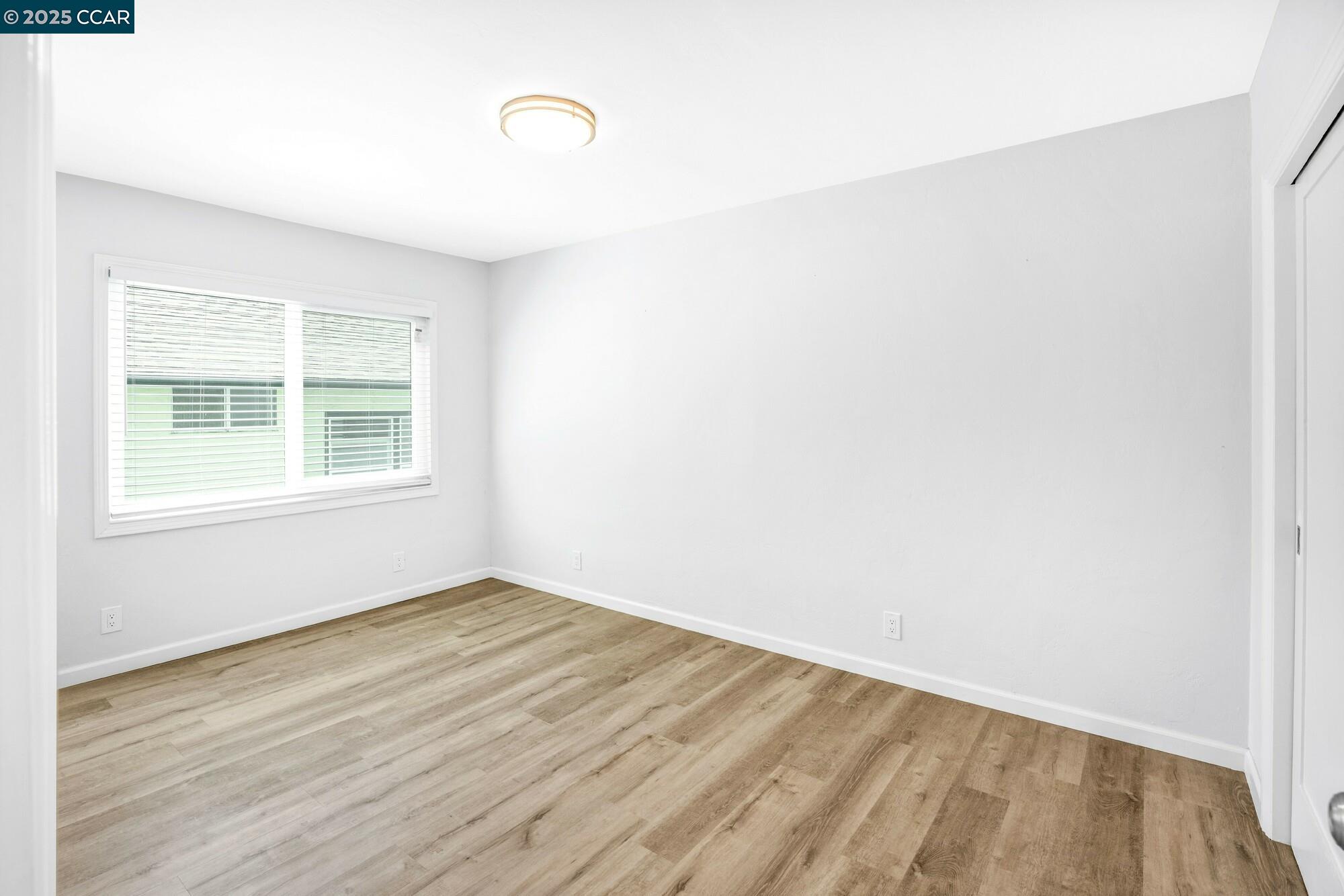 1919 Curtis Street Berkeley, CA 94702 - Photo 23 of 54 a view of an empty room with wooden floor and a window