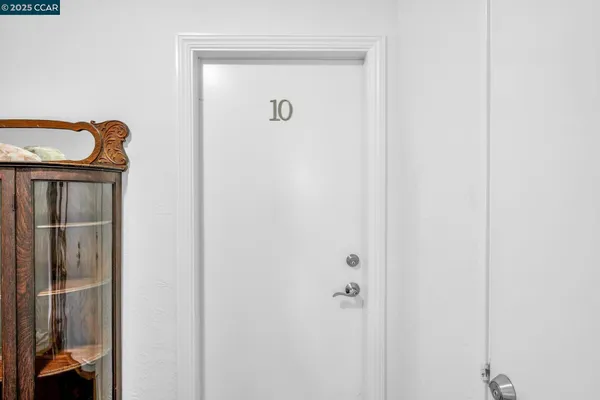 an empty room with wooden floor cabinet and windows