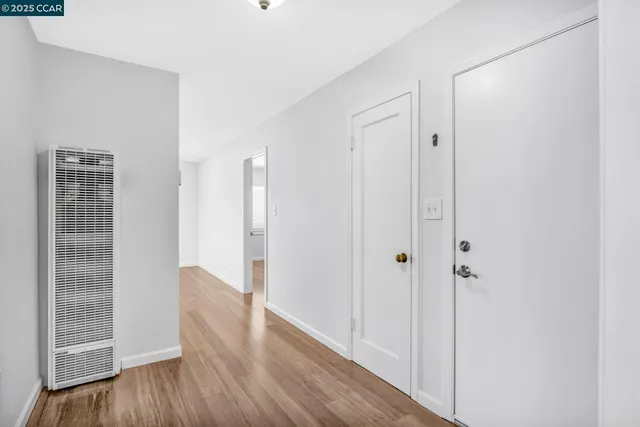 a view of a kitchen with wooden floor and natural light