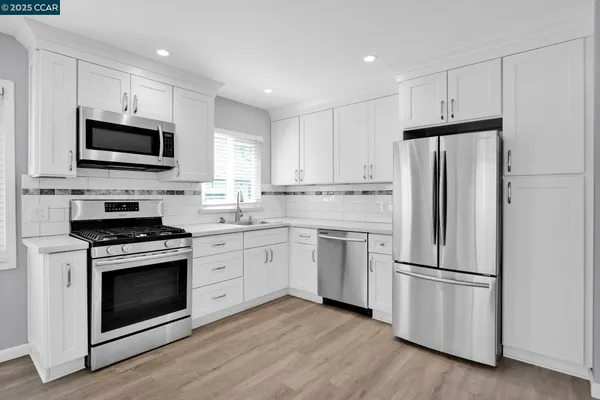 a kitchen with a stove a refrigerator and a microwave