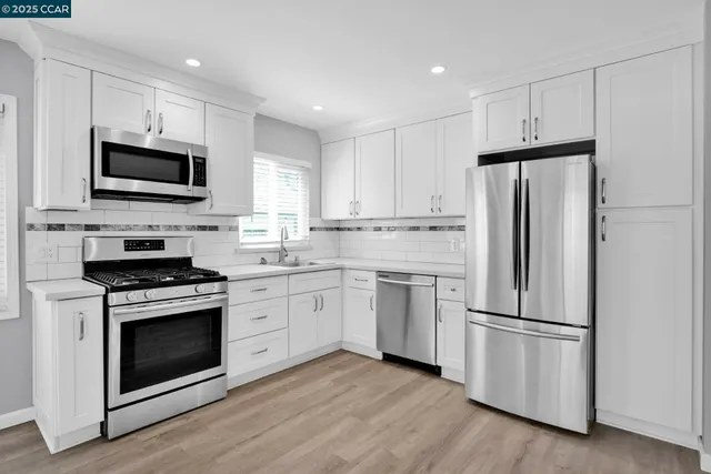 a kitchen with a stove a refrigerator and a microwave