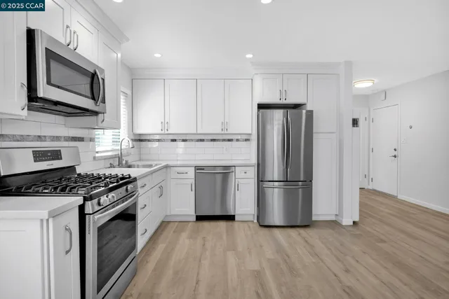 a kitchen with stainless steel appliances granite countertop a sink and cabinets