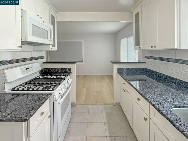 a kitchen with granite countertop a sink and a stove