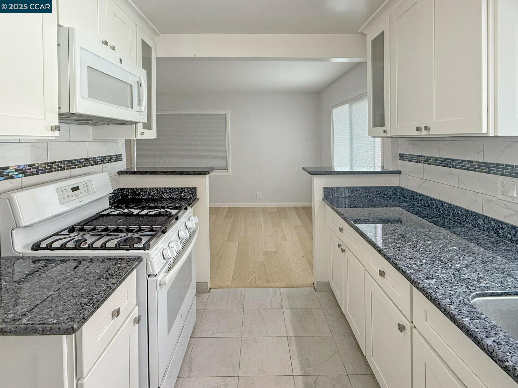1919 Curtis Street Berkeley, CA 94702 - Photo 45 of 54 a kitchen with granite countertop granite top and stainless steel appliances