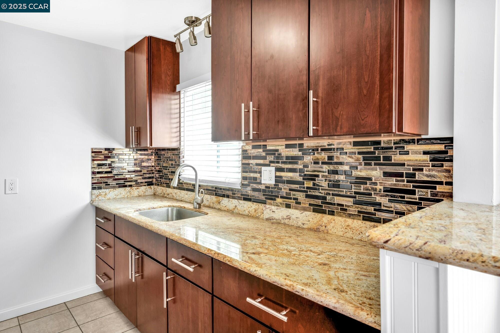 1919 Curtis Street Berkeley, CA 94702 - Photo 47 of 54 a kitchen with a sink and a wooden cabinets