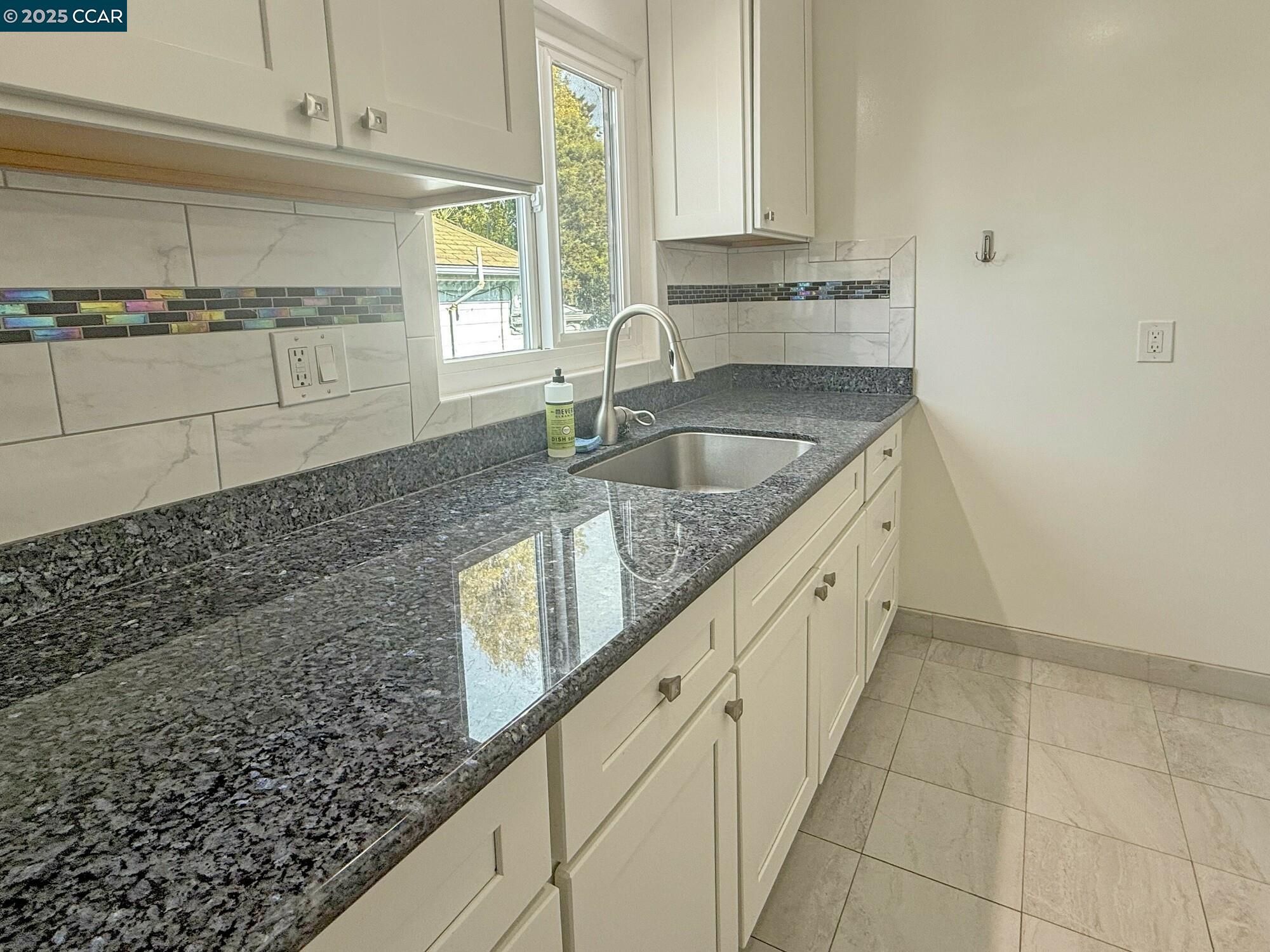 1919 Curtis Street Berkeley, CA 94702 - Photo 49 of 54 a kitchen with granite countertop a sink and a stove