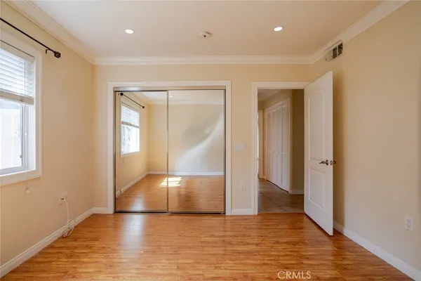 a view of empty room with wooden floor and fan