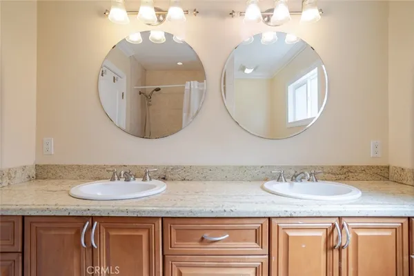 a bathroom with a granite countertop double vanity sinks and a mirror