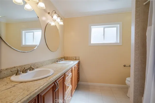 a bathroom with a granite countertop sink a mirror and a toilet