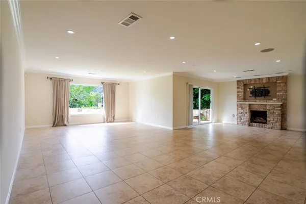 a view of an empty room with a fireplace and a window