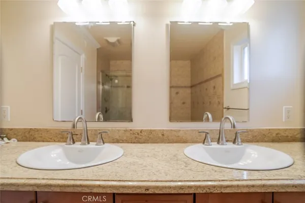 a bathroom with double vanity sinks and two mirror