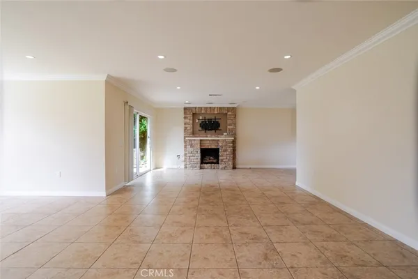 an empty room with a kitchen and a fireplace